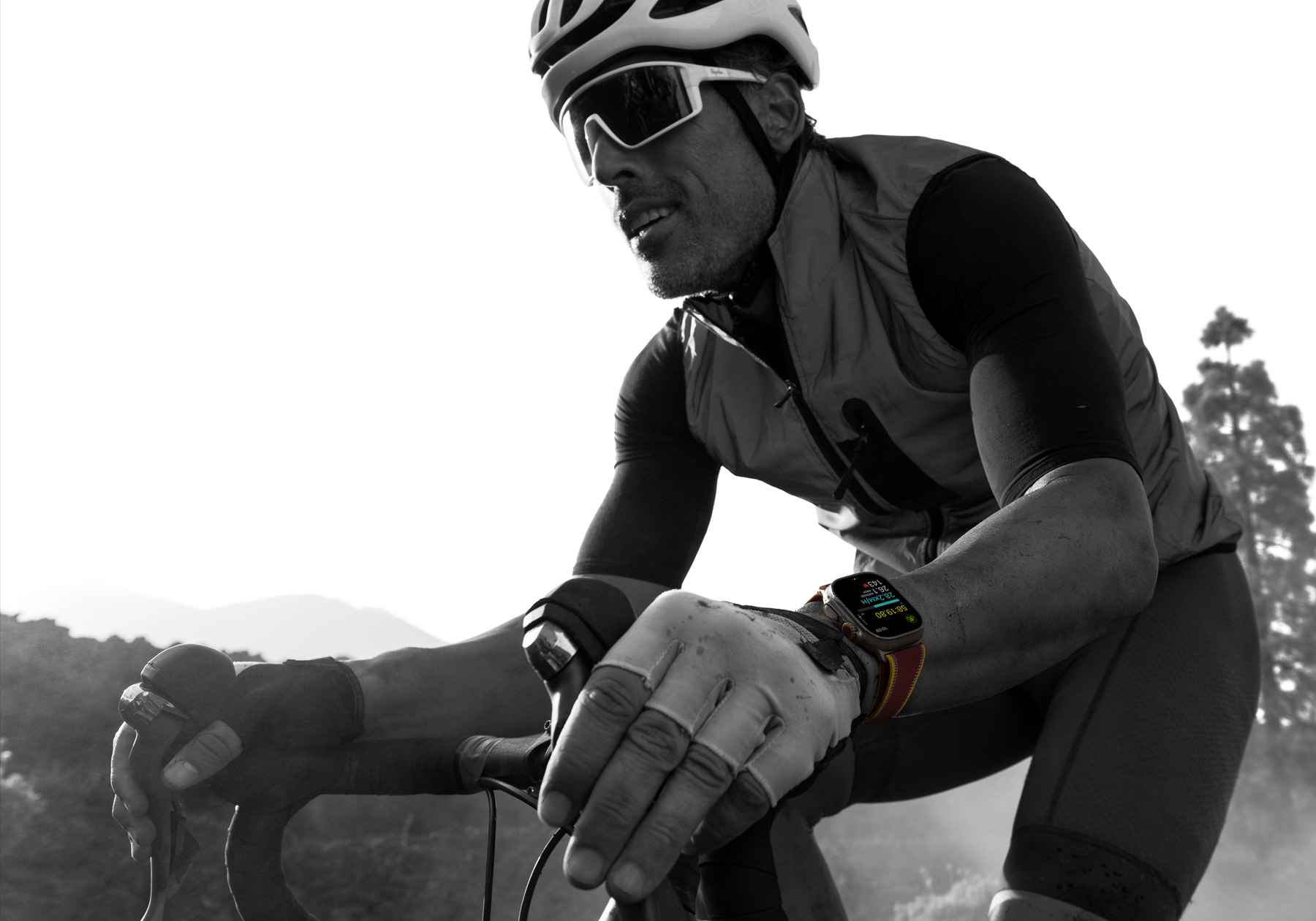 A person riding a road bike while wearing Apple Watch Ultra 4, screen shows cycling metrics