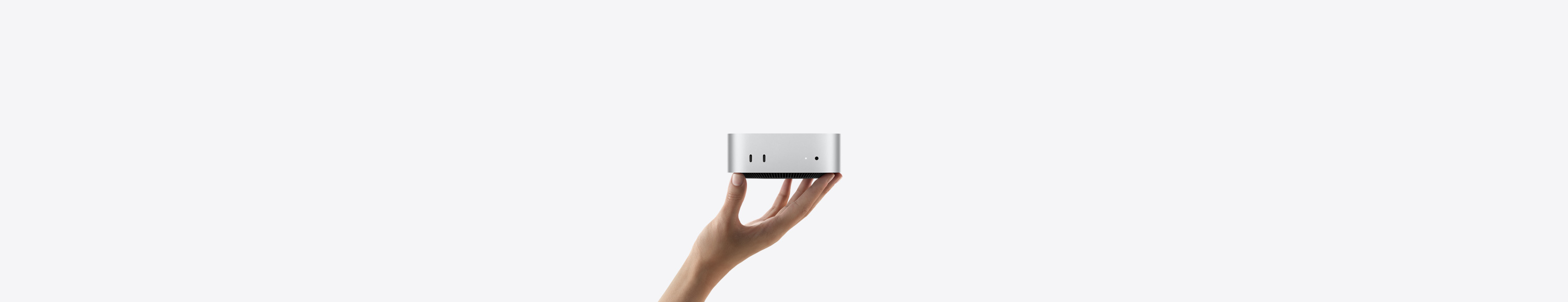 向上伸出的手以指尖平穩托着 Mac mini 的正面圖，展示其兩個 Thunderbolt 連接埠、狀態指示燈、耳筒插口及逐漸收窄黑色底座；採用平頂、圓渾側邊及平直邊框設計
