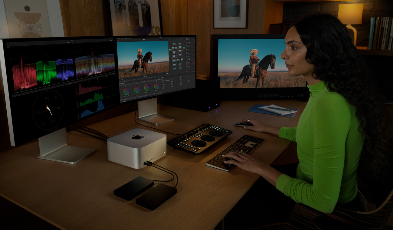 一位專業人士使用已連接 Mac&nbsp;Studio 的三部顯示器剪片